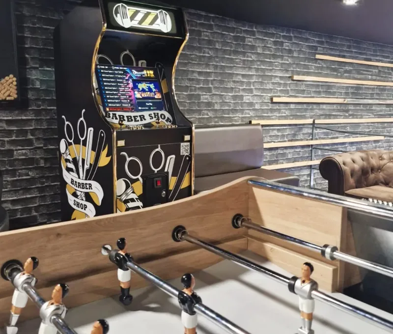 Borne d'arcade personnalisée et baby-foot dans un barbier